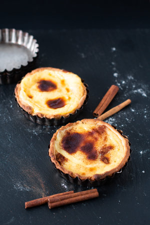Food concept Homemade organic egg  Portuguese Custard Tarts PASTEIS DE NATA on black slate stone...