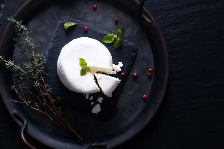 Local food concept organic fresh Goat cheese on black slate stone board background with copy spaceの写真素材