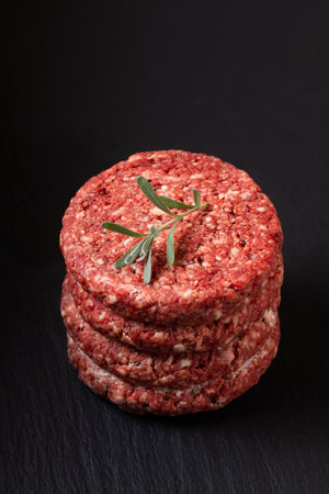 Food Concept Ground beef or hamburger beef patty stack on black slate board with copy spaceの写真素材