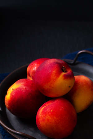 Food concept organic fruit Nectarine in rustic iron tray on black background with copy spaceの写真素材