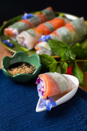 Healthy food concept Fresh smoked salmon rice paper spring rolls with colorful vegetable with copy spaceの写真素材