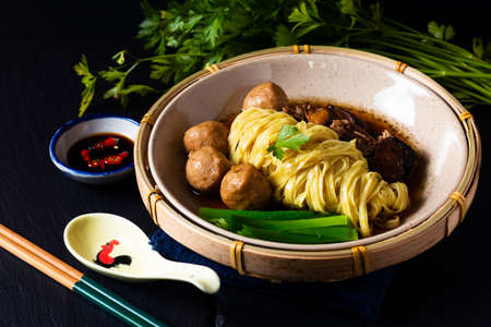 Asian Food Concept Chinese Egg noodle pork and meatball soup on black background with copy spaceの写真素材