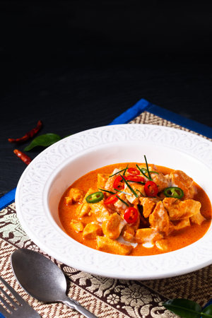 Thai Food concept Authentic Thai chicken Panang Curry, Panang Kai in ceramic bowl on black background with copy spaceの写真素材