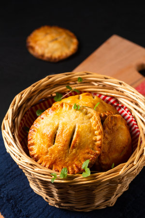 Food concept homemade rustic Ground Beef Pot hand Pie in bread basket on wooden board with copy...