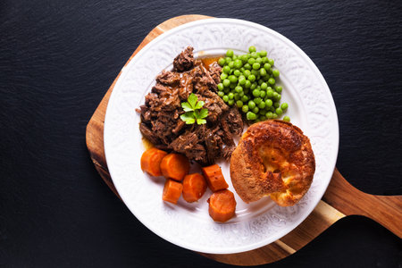 Food concept homemade Beer-Braised Shredded Beef with yorkshire pudding on black background with copy spaceの写真素材