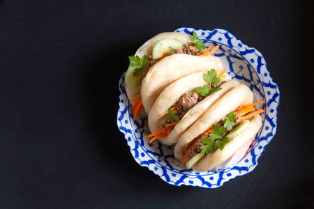 Food concept Homemade organic Pulled Beef Bao Buns or Gua Bao in asian ceramic plate on black background with copy spaceの写真素材