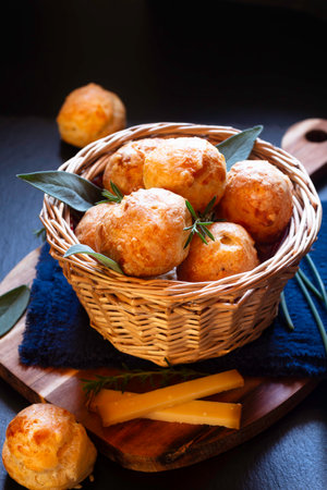 Food concept Spot focus French savory choux pastry gougÃ¨re, gougeres on black background with copy spaceの写真素材