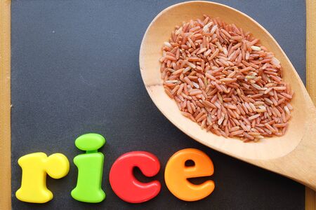 red rice in the spoon with blackboard backgroundの写真素材