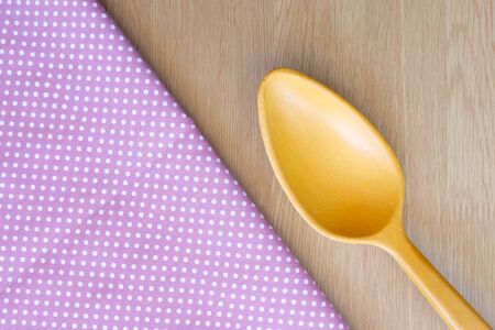 wooden spoon on wooden and dot cloth backgroundの写真素材
