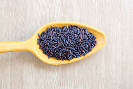 purple rice on wooden spoon with wooden backgroundの写真素材