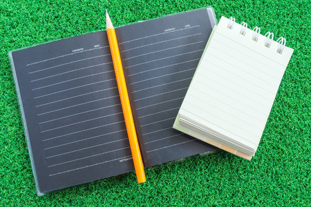 note book on green grass backgroundの写真素材