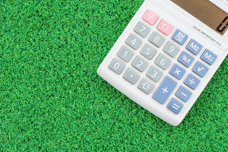calculator on green grass backgroundの写真素材