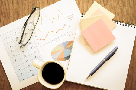 calculator and chart on the wooden table with vintage color styleの写真素材