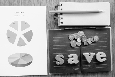 graph and note book on the wooden table with black and white colorの写真素材