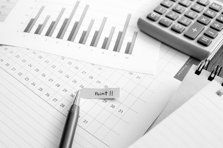 graph and planner on the wooden table with black and white colorの写真素材