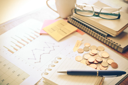 graph and money on the wooden table with vintage color conceptの写真素材