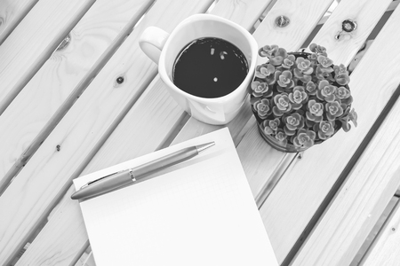 book and black coffee on wooden table with black and white colorの写真素材