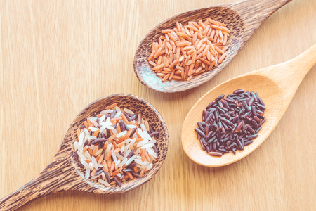three types of rice on wooden background with vintage colorの写真素材