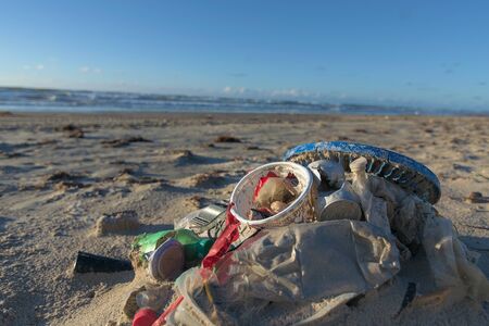 Garbage piled on beach polluting nature coastal errosion shrinking ecosystem destroyed by irresponsible people littering after party vacation.の写真素材