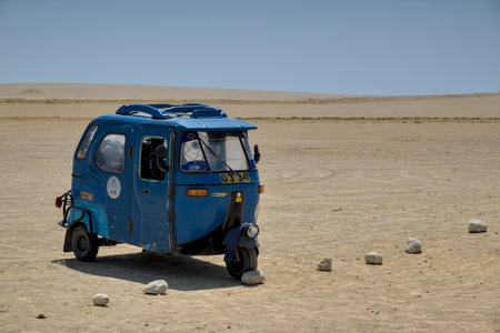 Blue tuk tuk three wheel taxi short distance transportation sits at peru natural reserve beach...