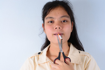 Quit smoking . Girl cutting cigarette with scissors.の写真素材