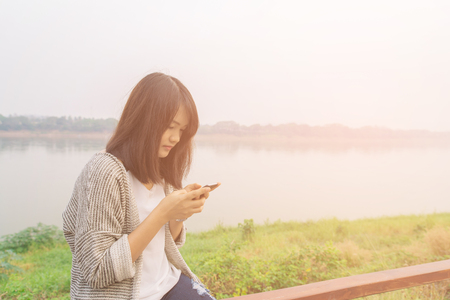 Closeup portrait upset sad skeptical unhappy serious woman talking texting on phone displeased with conversation isolated park outdoors background. Negative human emotion face expression feelingの写真素材