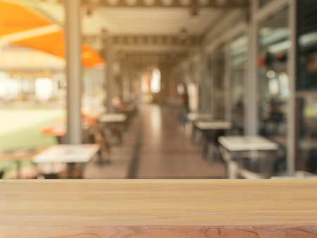 Wooden board empty table in front of blurred background. Perspective brown wood over blur in coffee...