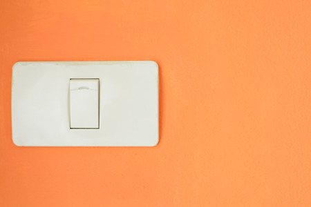 White light switch, turn on or turn off the lights on orange wall.の写真素材