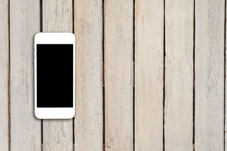 Top view smartphone mock up template with black screen on wooden table with copyspace.の写真素材