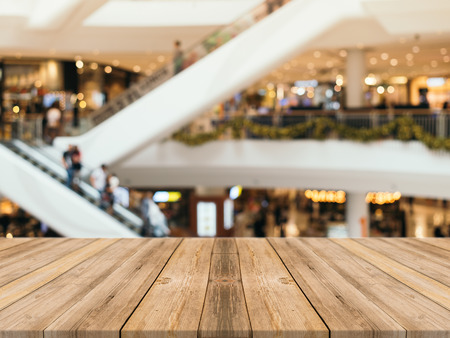 Wooden board empty table blurred background. Perspective brown wood table over blur in department store background - can be used for display or montage your products. Mock up for display of product.の写真素材