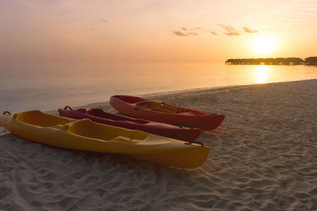 Kayak at the tropical beach at beautiful sunset. Silhouette beautiful tropical Maldives resort hotel and island with beach and sea on sunset sky for holiday vacation background concept.の写真素材
