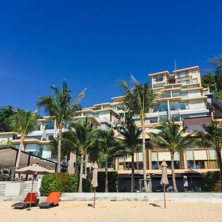 Large hotel and palm trees on the beach in Thailand.の写真素材