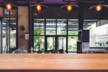 Wooden board empty table top on of blurred background. Perspective brown wood table over blur in coffee shop background - can be used mock up for montage products display or design key visual layout.の写真素材