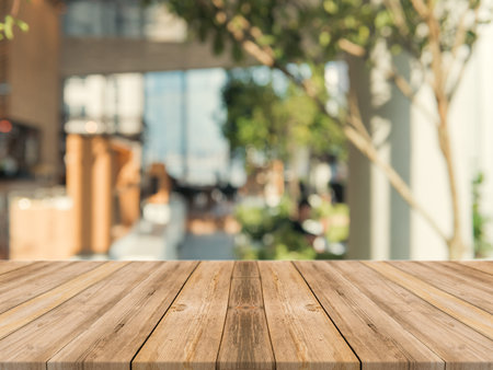 Wooden board empty table top on of blurred background. Perspective brown wood table over blur in...