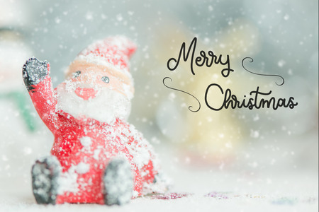 One ceramic santa claus Merry Christmas text on snowfall background. Lovely Merry Christmas and Happy New Year 2018 on snowfall background.の写真素材