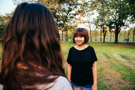 LGBT lesbian women couple moments happiness. Lesbian women couple together outdoors concept. Lesbian couple holding hands together relation fall in love. Two asian women having fun together at park.の写真素材