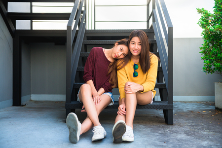 LGBT lesbian women couple moments happiness. Lesbian women couple together outdoors concept. Lesbian couple embraced together relation fall in love. Two asian women having fun together at rooftop.の写真素材