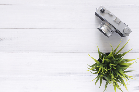 Minimal work space - Creative flat lay photo of workspace desk. Office desk wooden table with old camera. Top view with copy space. Top view of old camera over wooden table. Retro vintage filter.の写真素材