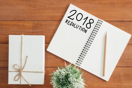 Minimal work space - Creative flat lay photo of workspace desk with New Year Resolution list notebook and wooden pencil on wooden background. Top view flat lay photography. 2018 happy new year conceptの写真素材