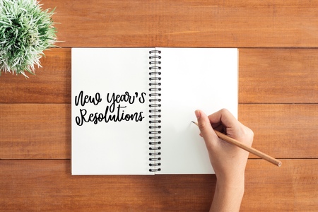 Wooden Work space - Flat lay view photo of working desk with a hand writing on  new year resolution in a notebook brown wooden background. Top View flat lay photography. New year 2018 wishing conceptの写真素材