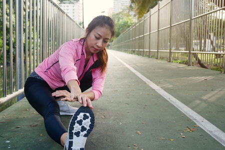 Fitness sport girl fashion sportswear doing yoga fitness exercise in street. Fit young asian woman doing training workout in morning. Young happy asian woman stretching at park after running workout.の写真素材