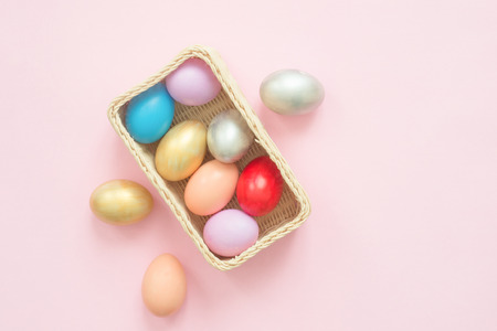 Flat lay top view colorful easter egg painted in pastel colors composition on pink pastel color background. Easter day background top view with copy space.の写真素材