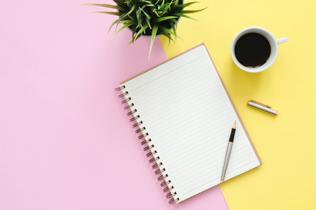 Creative flat lay photo of workspace desk. Top view office desk with mock up notebooks, plant, coffee cup and copy space on pastel color background. Top view with copy space, flat lay photography.の写真素材
