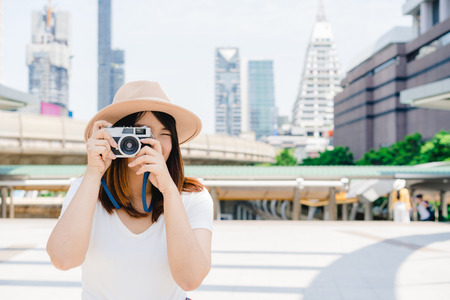 Happy beautiful traveler asian woman carry backpack. Young joyful asian women using camera to making photo during city tour, cheerful emotions, great mood. Women lifestyle outdoor in city concept.の写真素材