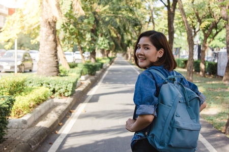 Summer lifestyle portrait of young tourist asian woman walking on the street, carry backpack.の写真素材