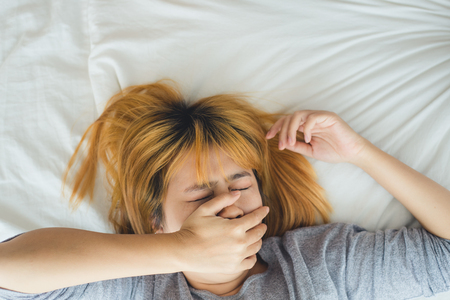Beautiful young Asian woman sleeping in bed in the morning. Attractive asian girl use bedtime in her comfortable bedroom. Relaxation bedroom. Iifestyle asia woman at home concept.の写真素材