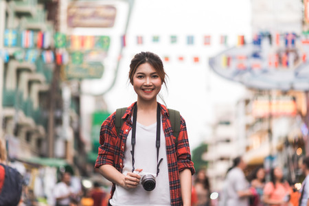 Traveler backpacker asian woman travel in Khao San road at Bangkok, Thailand. Happy young female spending holiday trip at amazing landmark and enjoy her journey in traditional city.の写真素材
