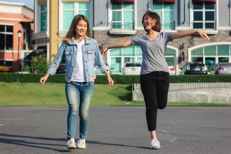 Group of young Asian women walking in an outdoor market in urban city, cheerful beautiful female feeling happy travel together. Lifestyle women travel holiday together concept.の写真素材