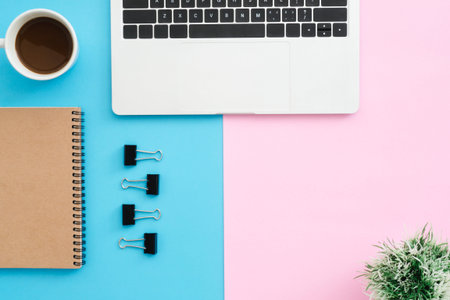 Creative flat lay photo of workspace desk. Top view office desk with laptop, clip, notebook, coffee...