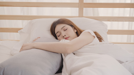 Asian woman dreaming while sleeping on bed in bedroom, Beautiful japanese female using relax time lying on bed at home. Lifestyle women using relax time at home concept.の写真素材